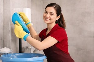 Professional home cleaning service in Dubai by Helen Maid cleaner in red uniform